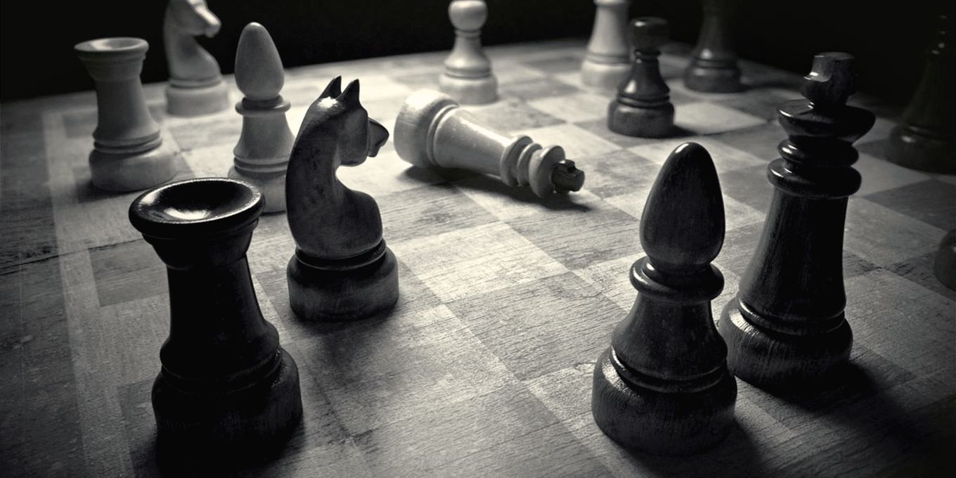 Chess pieces in the middle of a game on a dark board