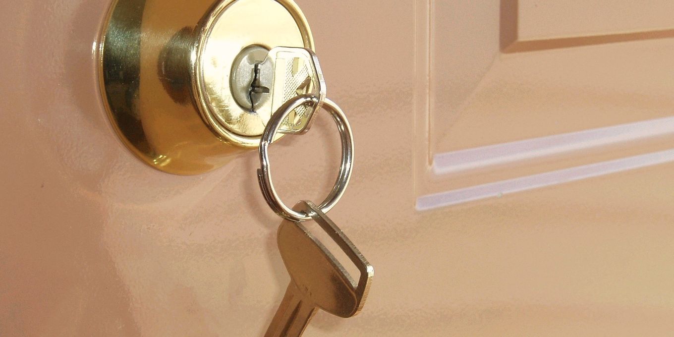 A key ring hanging from a brass lock in a door